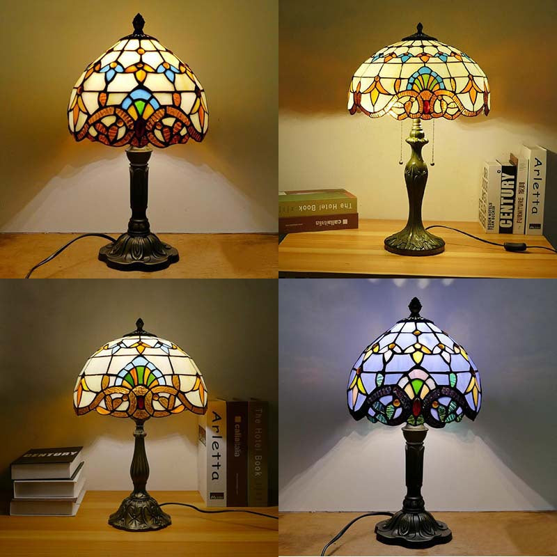 Creative colored glass bedside desk lamp with artistic stained glass shade and elegant resin base providing warm ambient light for bedroom or study.