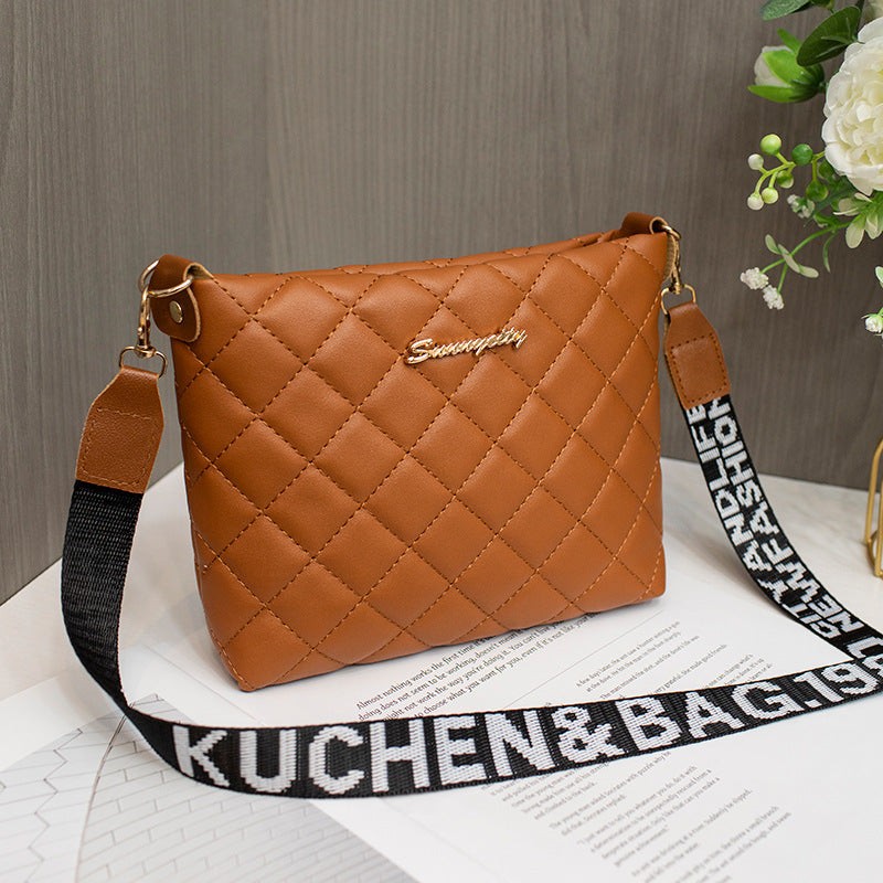 Brown small messenger bag with quilted diamond pattern and black adjustable shoulder strap with white text, stylish and compact crossbody purse for women.