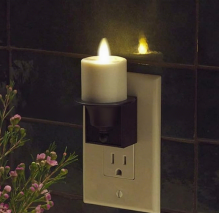 Luminara Flameless Candle Nightlight plugged into wall outlet with realistic flickering flame effect in cozy room setting