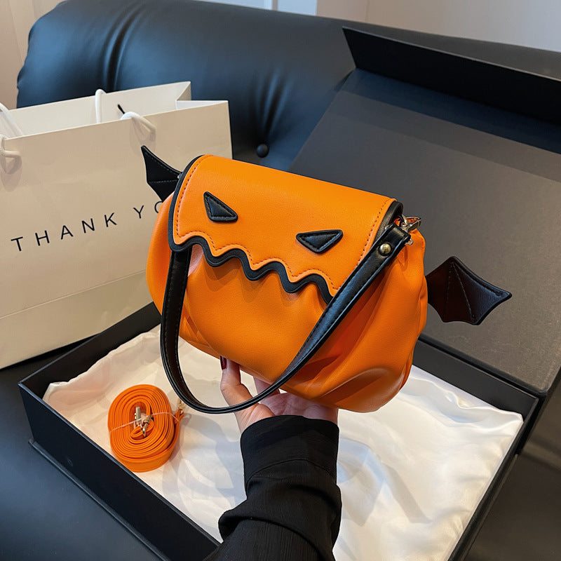 Orange Halloween pumpkin crossbody bag with black wings and cartoon face design, stylish and fun handbag for women
