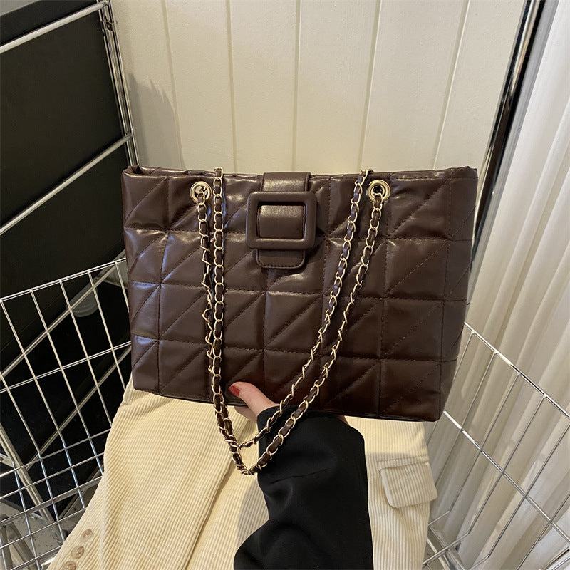 Brown quilted PU leather women shoulder bag with rhombus pattern and chain strap, trapezoid shape, soft texture.