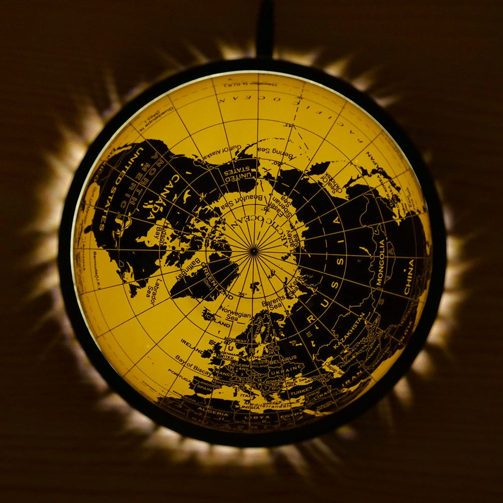 Magnetic levitation globe night light glowing with warm yellow illumination, modern office decor
