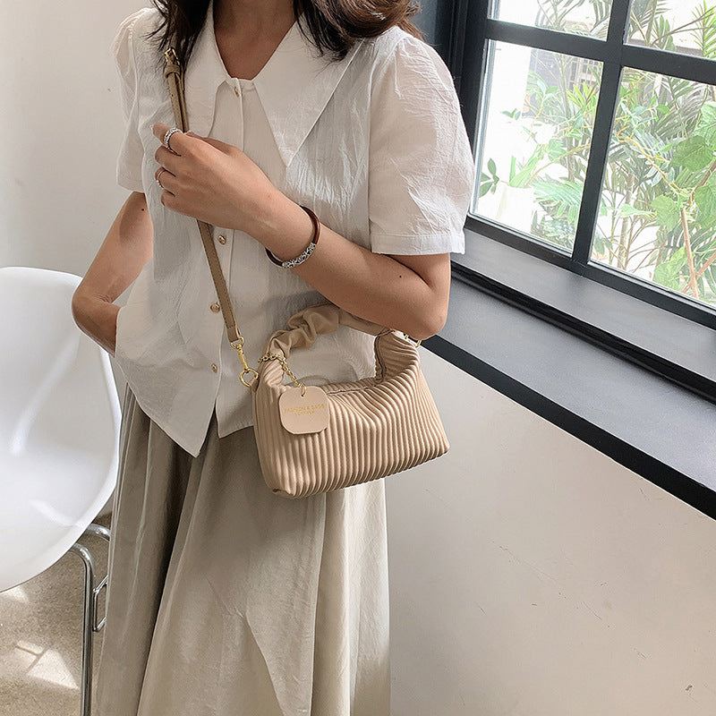 Women fashion crossbody bag in beige pleated PU leather with adjustable strap, compact and elegant tote for casual use.