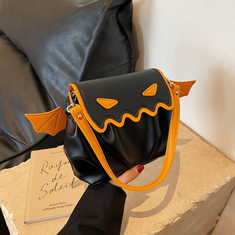 Black and orange Halloween pumpkin cartoon crossbody bag with small wings and wavy edge design
