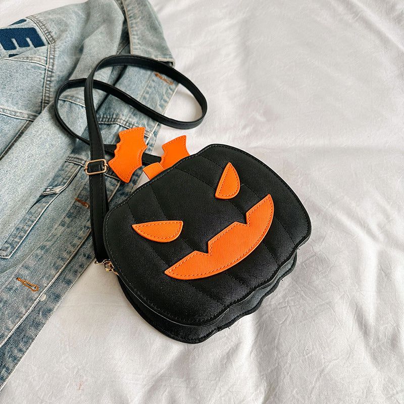 Black Halloween crossbody bag with orange pumpkin face and bat-shaped zipper pull, stylish and cute shoulder bag for women
