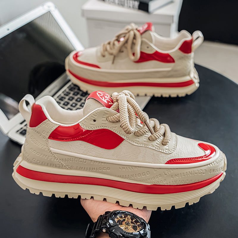 Beige and red men's outdoor sneakers with thick sole and lace-up design held above a laptop keyboard