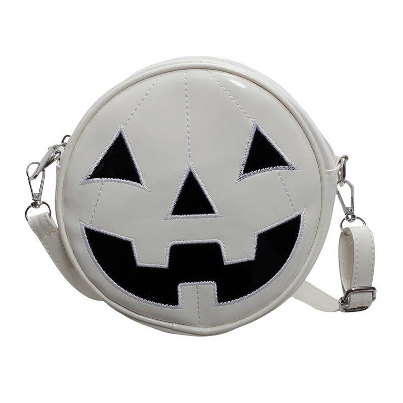 Small round white Halloween pumpkin shoulder bag with black jack-o'-lantern face and adjustable crossbody strap