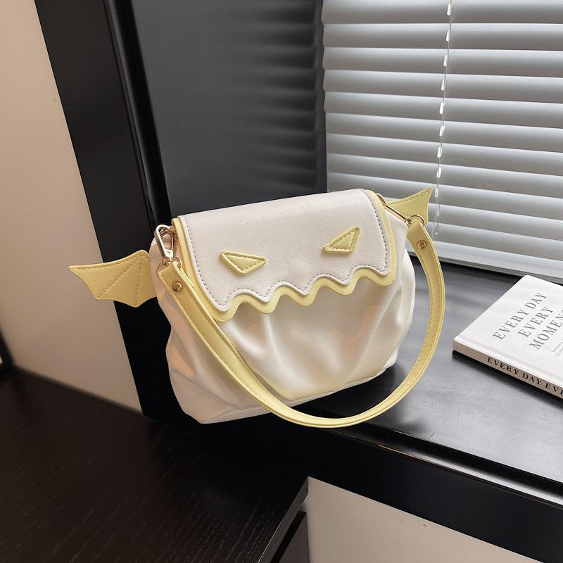 Funny Halloween pumpkin crossbody bag with small wings and cartoon face design in white and yellow.